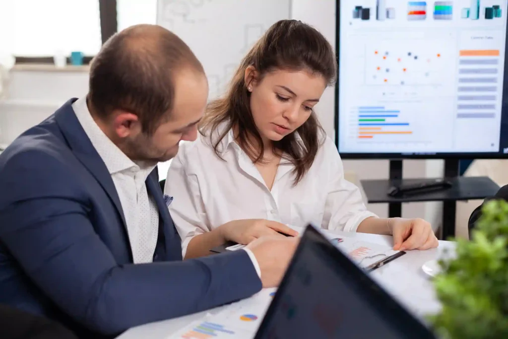 Colleagues Startup Business Discussing Looking Documents Company Board Brainstorming Conference Room Checking Graphs Charts 11zon 11zon - ERJ Assessoria Contábil e Tributaria
